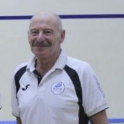 An image of George Tierney standing on a squash court during a prize giving.