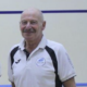An image of George Tierney standing on a squash court during a prize giving.